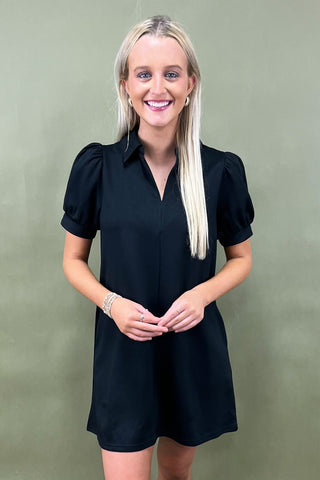 Woman wearing a black dress against a green background