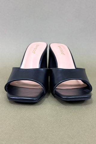 Pair of navy blue slides with pink interior on a gray background