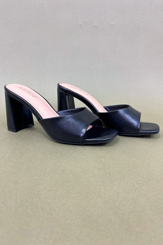 Pair of black open-toe high-heeled shoes on a light gray background