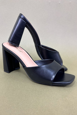 Black high-heeled shoes on a beige background