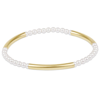 Bracelet with gold bands and white pearls on a white background