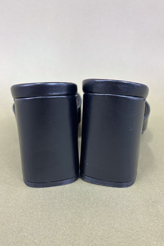 Pair of navy blue rubber boots on a light gray background