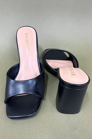 Pair of black slides with pink insole on a gray background