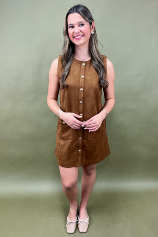 Woman wearing a brown dress against a green background