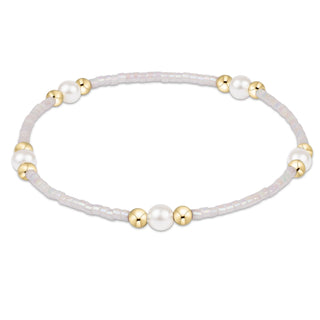 Bracelet with white beads and gold accents on a white background