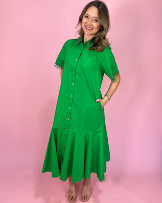 Woman wearing a green dress against a pink background