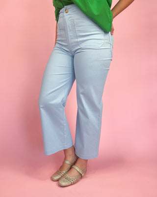 Light blue jeans worn by a person on a pink background