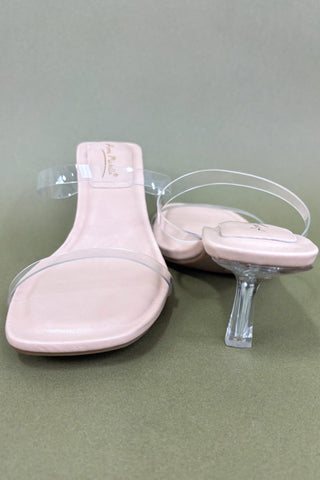 Pink high-heeled shoes with clear heel and toe sections on a gray background