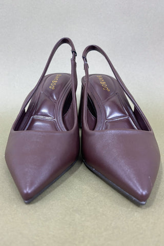 Pair of brown high-heeled shoes on a beige background