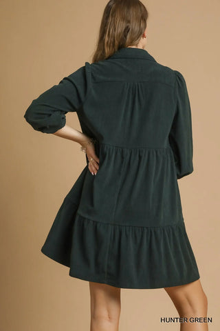 Green dress worn by a person on a beige background