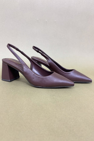 Pair of purple slingback heels on a beige background