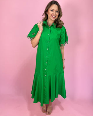 Woman wearing a green dress with lace details on a pink background
