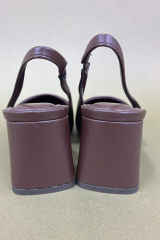 Pair of purple wedge sandals on a light gray background