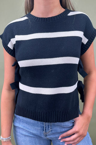 Black and white striped knit top with side bow details styled with light wash wide leg frayed hem jeans and gold loafers
