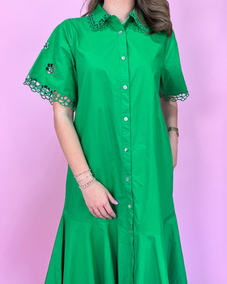 Green dress with lace details on a pink background