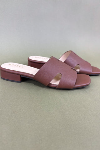 Pair of maroon sandals on a light gray background