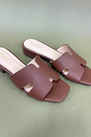 Pair of brown sandals on a green background