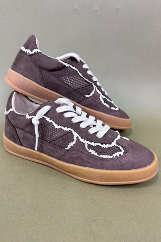 Pair of brown sneakers with white laces on a gray background