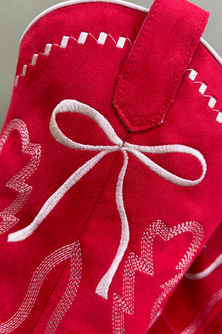 Red fabric with white embroidered hearts and a bow