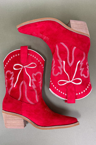 Red cowboy boots with white embroidery on a gray background