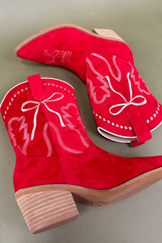 Red cowboy boots with white embroidery on a gray background