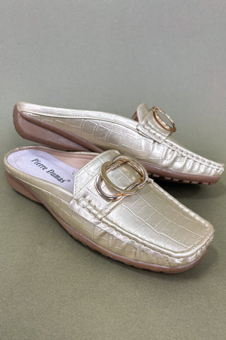 Pair of light pink slip-on shoes with a gold buckle on a gray background