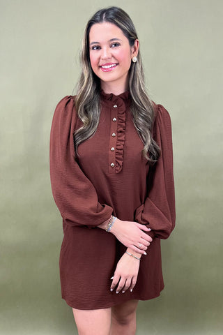 Woman wearing a brown dress against a green background