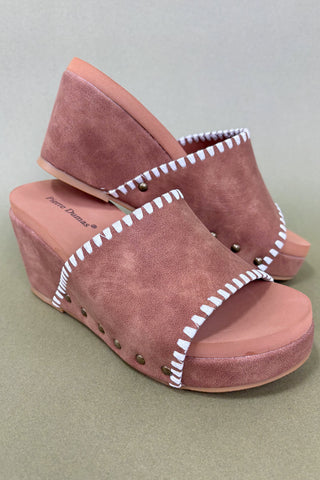 Pair of pink suede platform sandals with white stitching on a light gray background