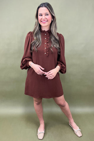 Woman wearing a brown dress against a green background