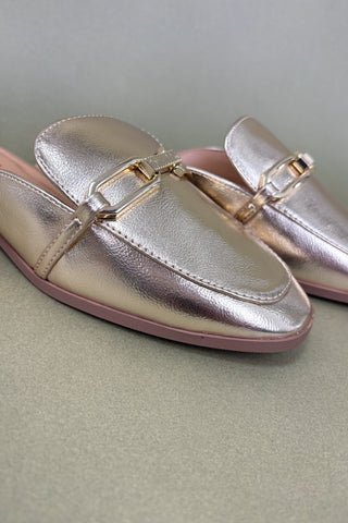 Pair of metallic pink loafers on a light gray background