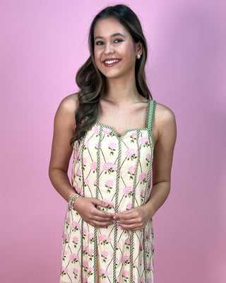 Woman wearing a floral dress against a pink background
