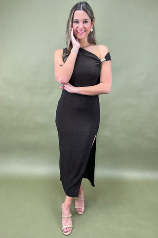 Woman wearing a black one-shoulder dress against a green background