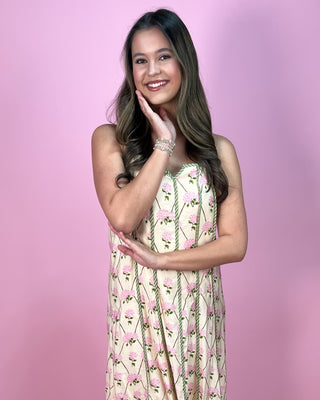 Woman wearing a floral dress against a pink background