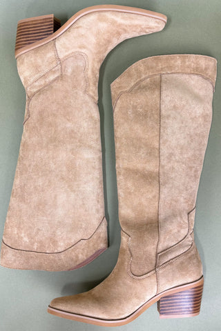Pair of beige knee-high boots on a gray background