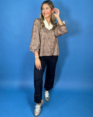 Leopard print blouse with a contrasting cream ruffle collar, three-quarter puff sleeves, and feminine ruffle cuff details.