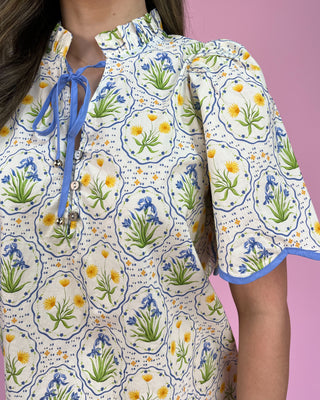 Close-up of a floral patterned dress with blue accents on a pink background