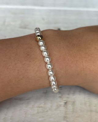 Pearl bracelet on a wrist with a marble background