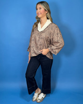 Leopard print blouse with a contrasting cream ruffle collar, three-quarter puff sleeves, and feminine ruffle cuff details.