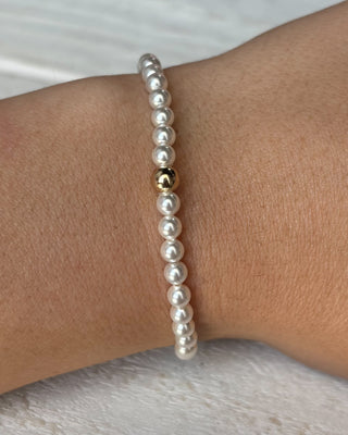 Pearl bracelet on a wrist with a neutral background