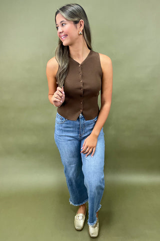 Brown ribbed button-front sleeveless top styled with light wash wide leg frayed hem jeans and gold loafers