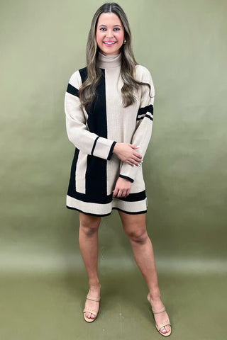 Woman wearing a black and white striped dress against a green background