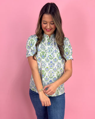 Woman wearing a floral blouse against a pink background