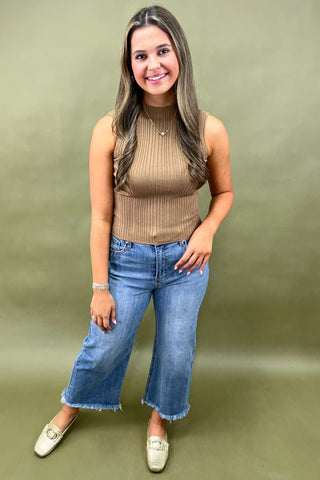 Camel ribbed sleeveless mock neck top styled with light wash wide leg frayed hem jeans and gold loafers