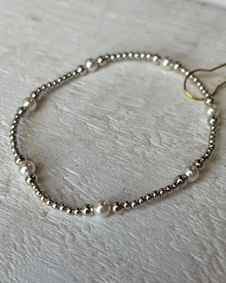 Bracelet with pearls and beads on a light wooden surface