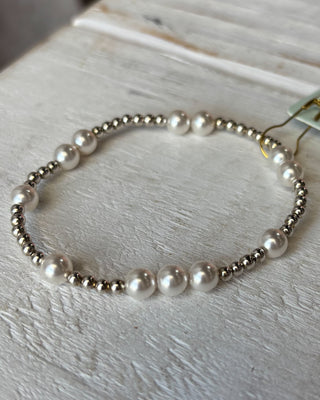 Bracelet with pearls and silver beads on a light wooden surface
