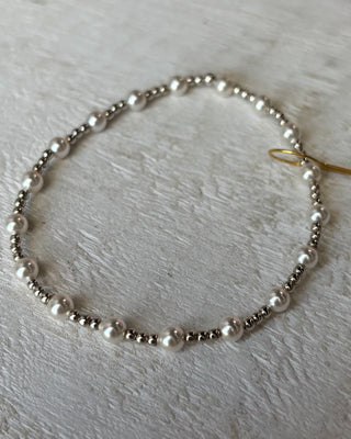 Pearl necklace on a light wooden surface