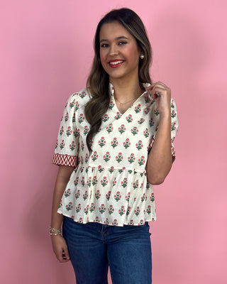 Woman wearing a floral blouse with a pink background