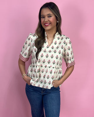 Woman wearing a floral blouse with a pink background