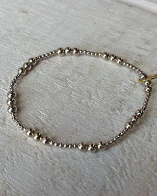 Silver beaded bracelet on a light wooden surface