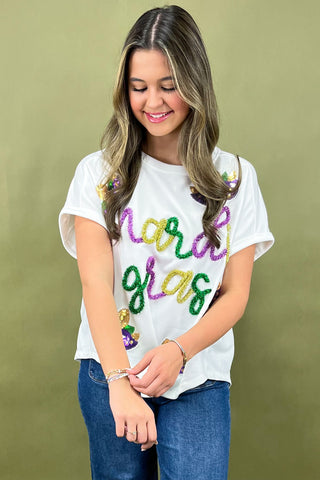 Person wearing a white t-shirt with colorful text on a green background